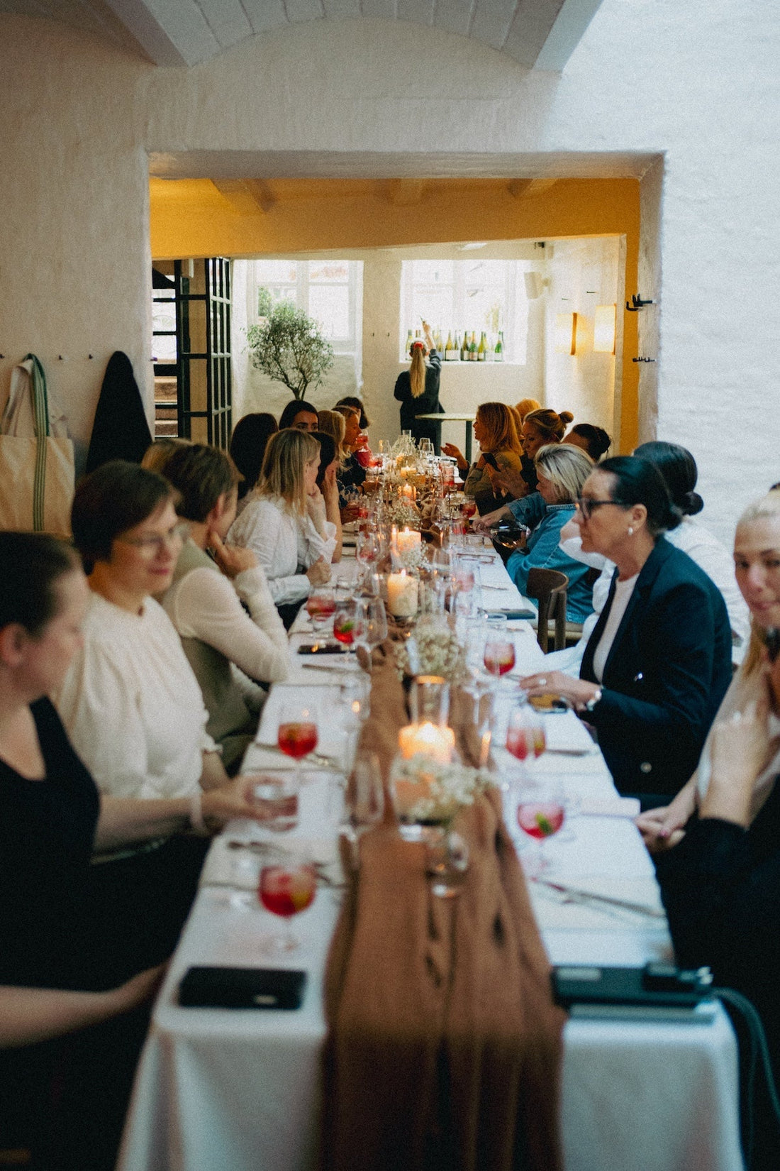 Elegant group dining event with candles, fabric table runner, and TAMEKO-inspired decor