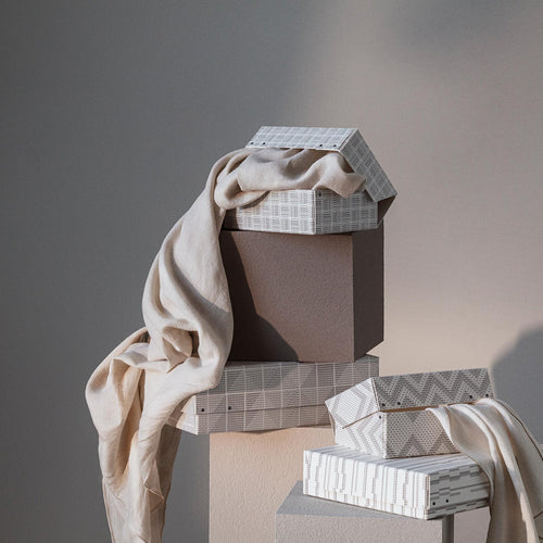 Neutral fabric draped over geometric TAMEKO boxes, soft natural light, minimalist home decor