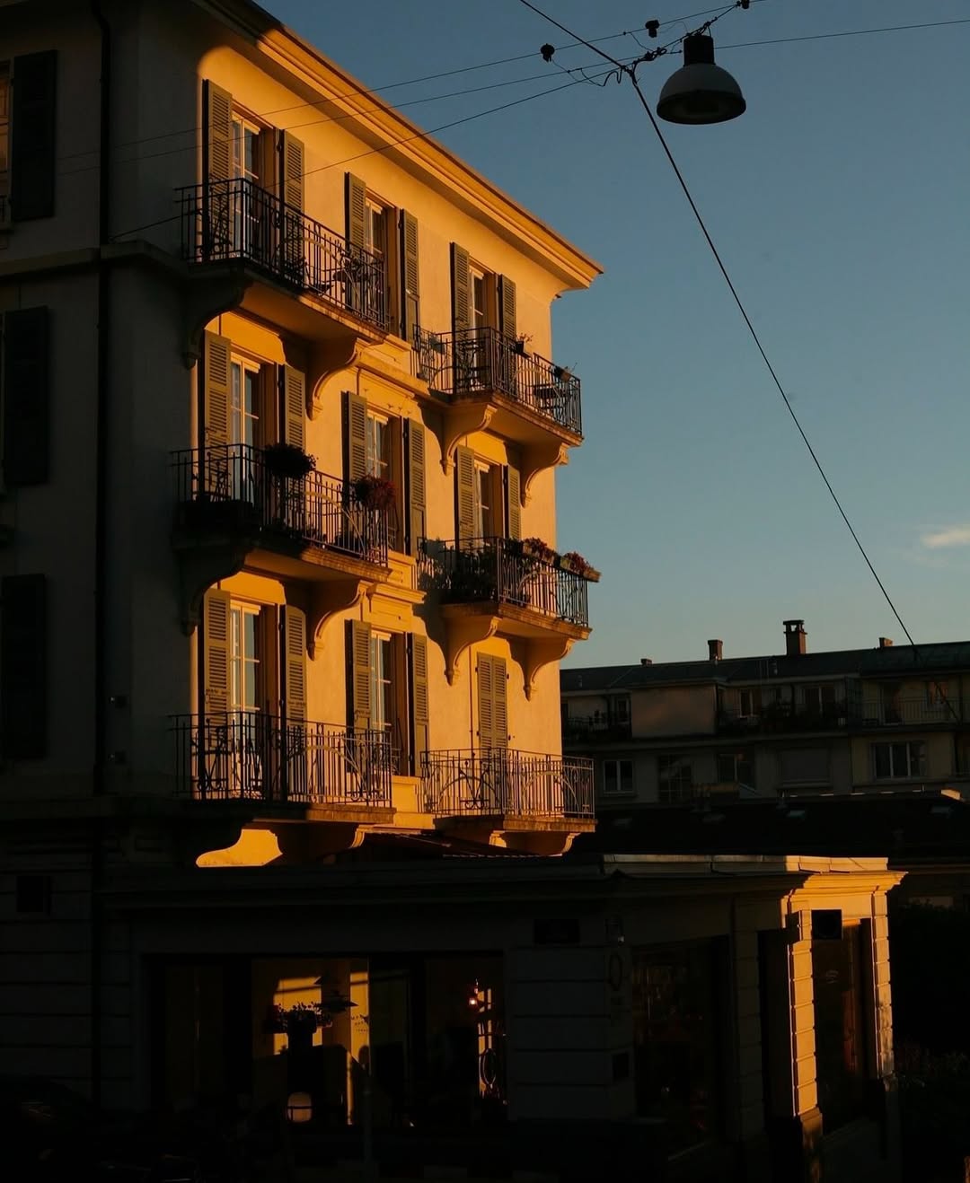 Charming yellow building with balconies in sunset light, reflecting TAMEKO’s natural home style
