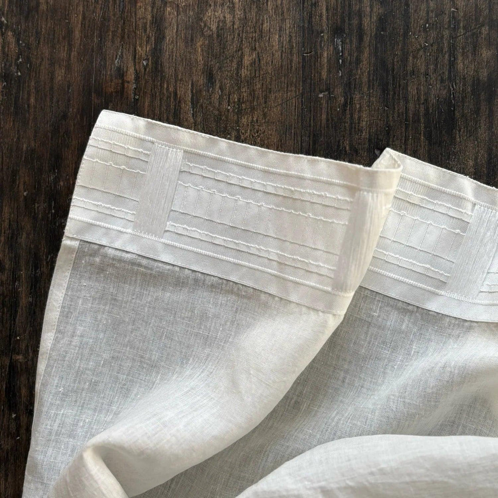 White linen curtain with multifunctional tape on dark wood background by TAMEKO