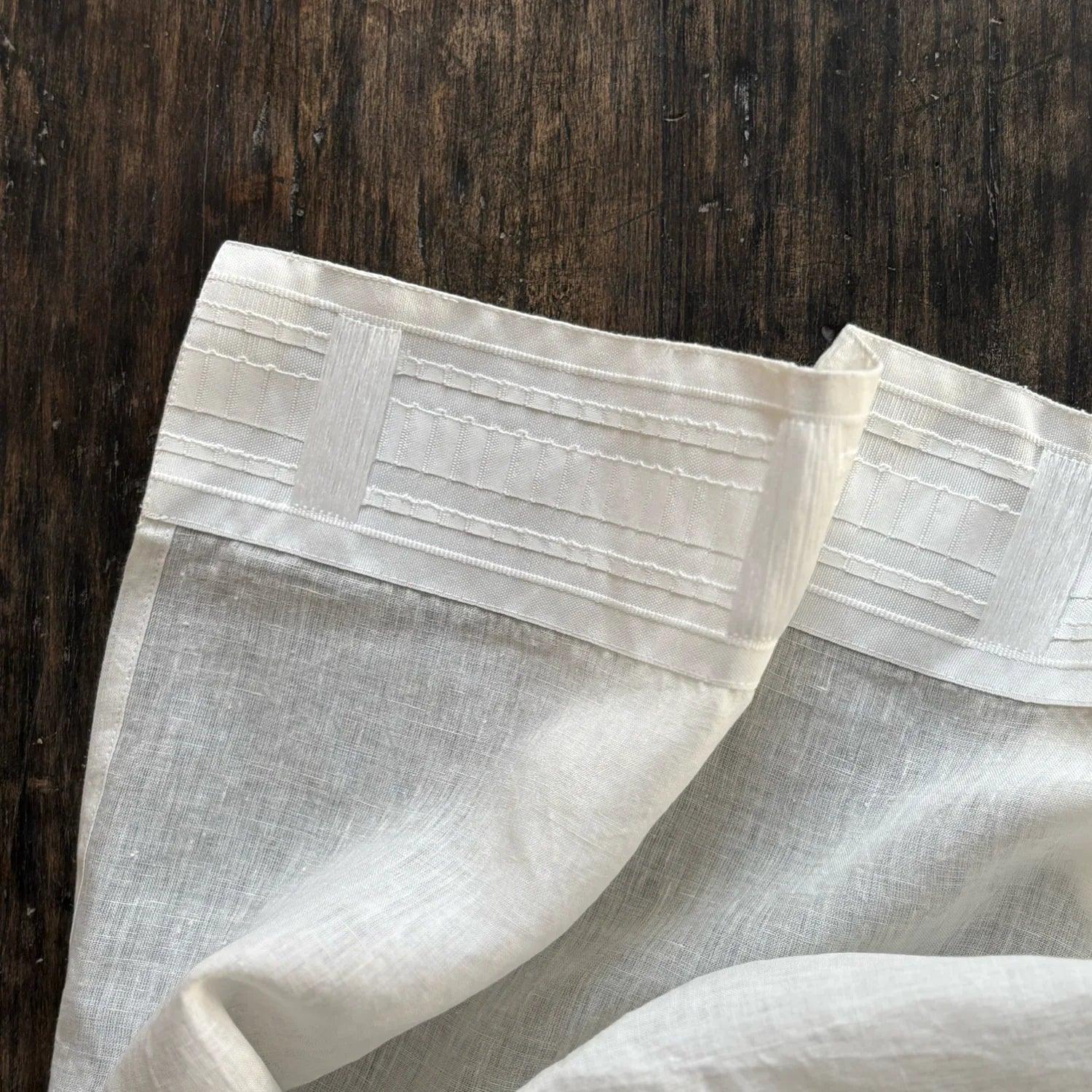 White linen curtain with multifunctional tape on dark wood background by TAMEKO