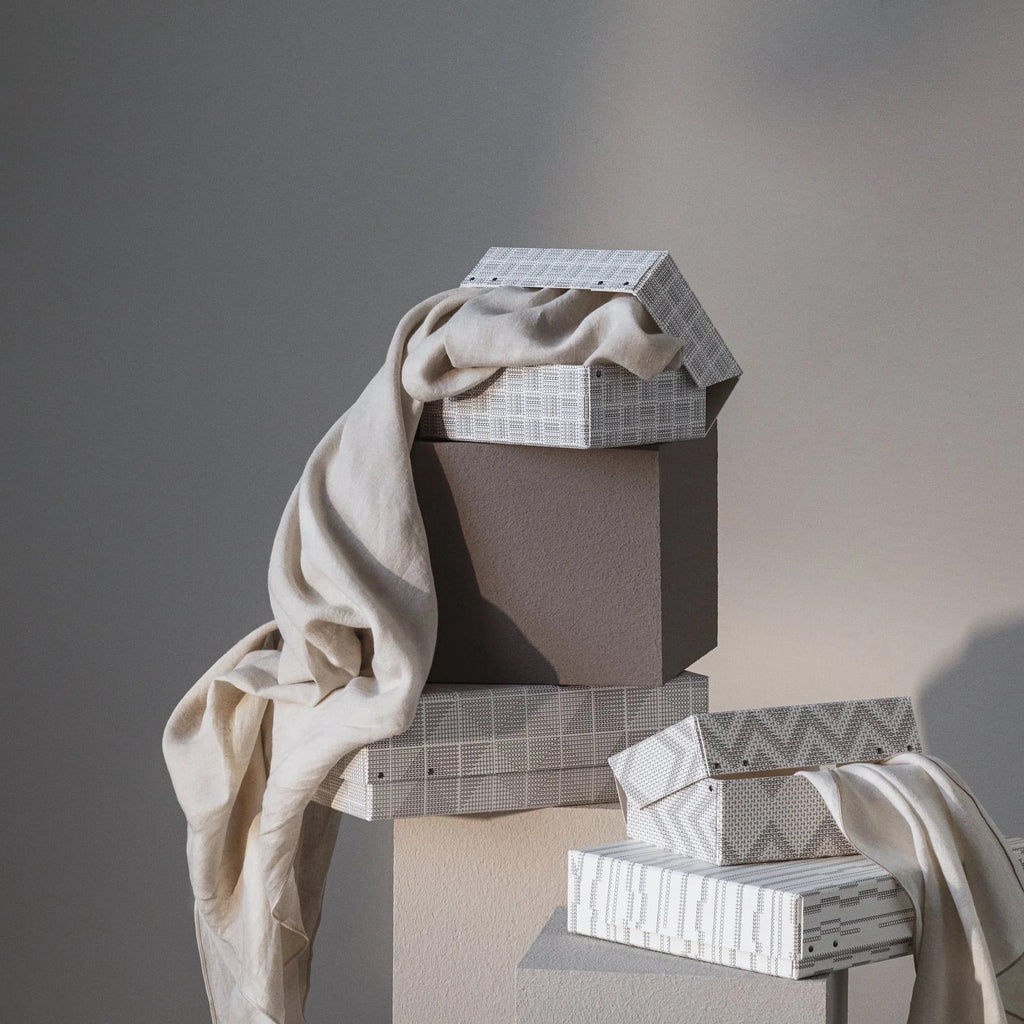 Neutral patterned TAMEKO fabric boxes with draped beige linen in soft natural light.