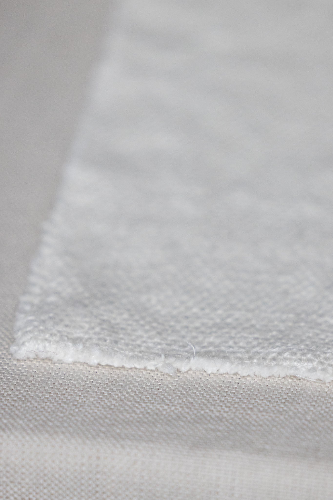 Close-up of TAMEKO textured white fabric, showcasing natural woven detail.