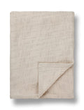 Neutral linen bed throw with textured weave, folded neatly, TAMEKO home fabric